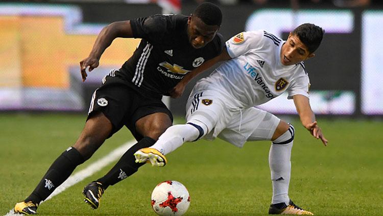 Timothy Fosu-Mensah (kiri) tengah berusaha merebut bola dari Jefferson Savarino.
