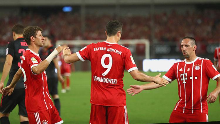 Robert Lewandowski melakukan selebrasi bersama Thomas Mueller (kiri) dan Franck Ribery. Copyright: INDOSPORT