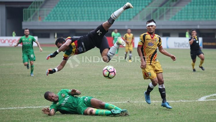 Joko Ribowo (atas) berusaha menangkap bola dari serangan Bhayangkara FC. FOTO INDOSPORT/Herry Ibrahim.