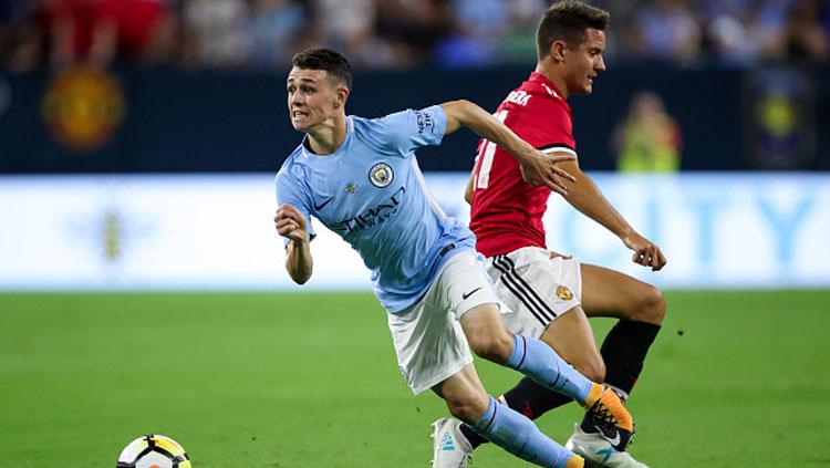 Phil Foden ketika melewati Ander Herrera.