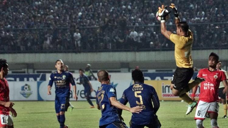 Andritany Ardhiyasa berhasil mengamangkan bola dari serangan Persib Bandung. Copyright: @kumparan