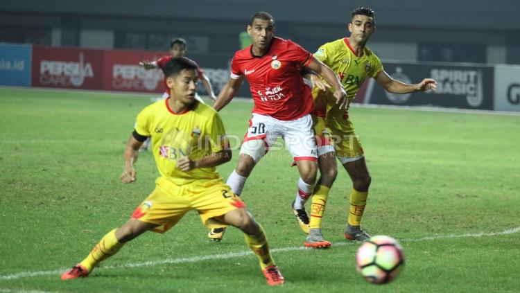 Pemain Persija Jakarta, Bruno Lopes berhasil mengeksekusi bola meski dikawal pemain Bhayangkara FC. INDOSPORT/Herry Ibrahim.