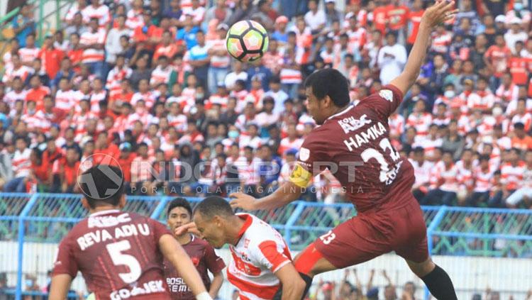 Hamka Hamzah terbang tinggi saat menghalau bola udara yang menuju Peter Odemwingie. FOTO: Ian Setiawan/Indosport.com.