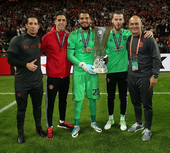 Tiga kiper Man United, Joel Pereira (merah), Sergio Romero (tengah), dan David De Gea (kanan) bersama dua pelatih kiper Man United berfoto bersama trofi Liga Europa 2016/17. Copyright: INDOSPORT