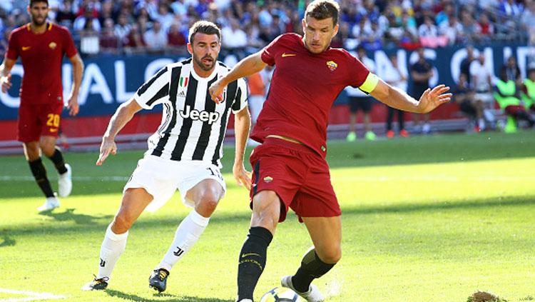 Andrea Barzagli (Juventus) tampak fokus memperhatikan bola yang tengah dikontrol oleh Edin Dzeko.