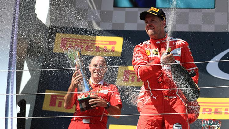 Sebastian Vettel selebrasi dengan menyemprotkan bir.