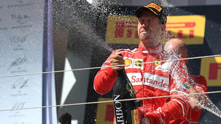 Sebastian Vettel selebrasi dengan menyemprotkan bir.