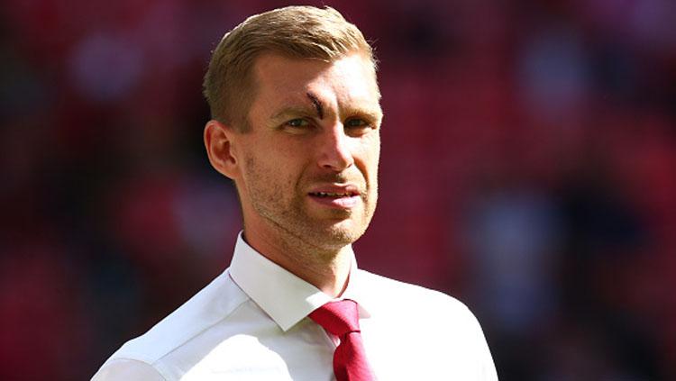 Per Mertesacker mengalami luka di bagian mata. Copyright: INDOSPORT