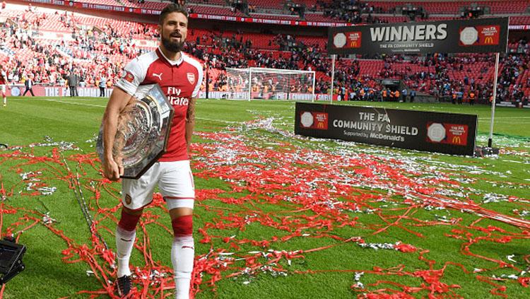 Olivier Giroud membawa trofi Community Shield.