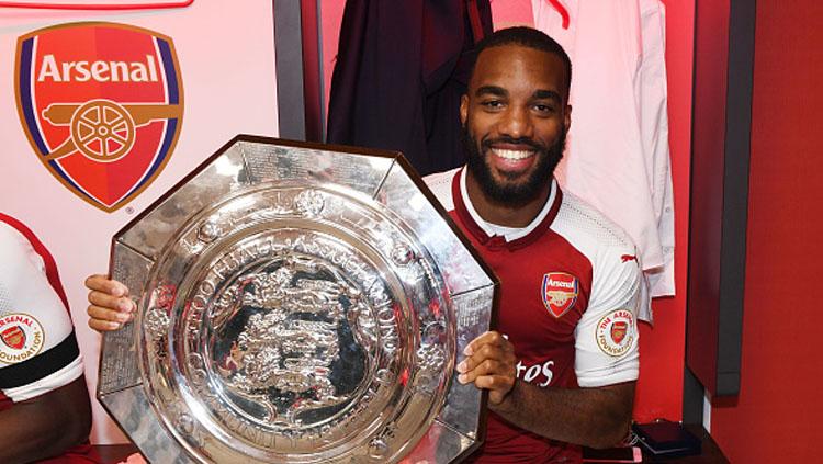 Alexandre Lacazette tersenyum lebar setelah memenangkan trofi Community Shield 2017.