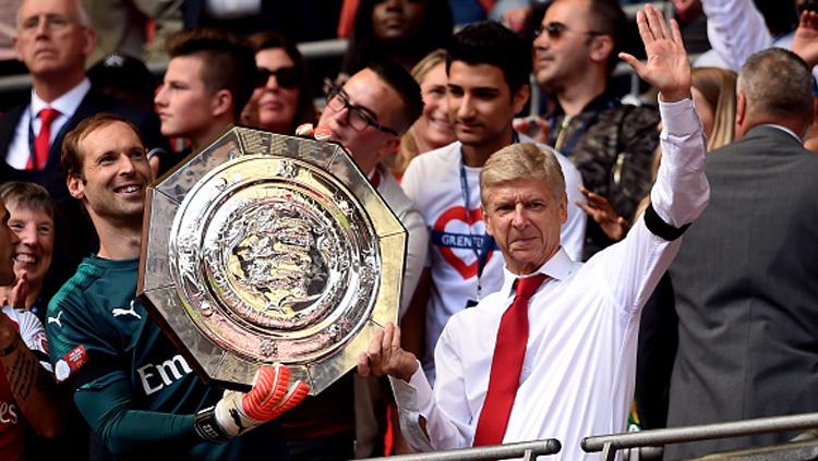 Arsene Wenger melambaikan tangan kepada media usai Arsenal berhasil menjuarai Community Shield.