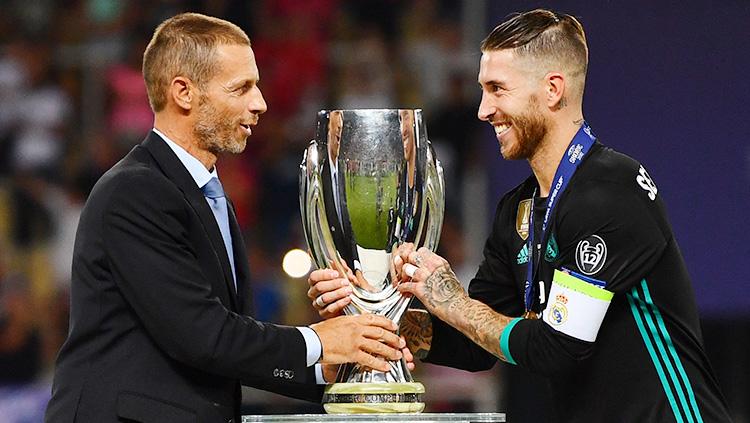 Presiden UEFA, Aleksander Ceferin, menyerahkan gelar Piala Supoer Eropa kepada kapten Real Madrid, Sergio Ramos.