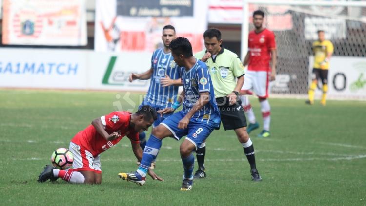 Ramdani Lestaluhu (kiri bawah) dilanggar pemain Persiba di depan wasit asing yang memimpin pertandingan, Rysbek Shekerbekov. Copyright: Herry Ibrahim/Soicaumienbac.cc