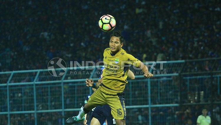 Ahmad Jufriyanto melompat tinggi dalam duel udara dengan pemain Arema. Copyright: Ian Setiawan/INDOSPORT