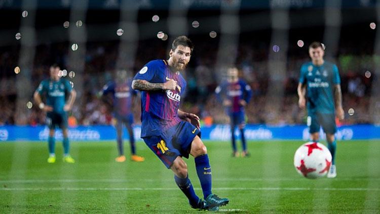 Lionel Messi menendang bola dari titik kotak penalti.