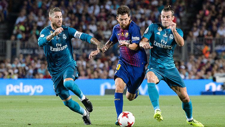 Sergio Ramos (kiri) dan Gareth Bale berusaha menggagalkan aksi Lionel Messi.
