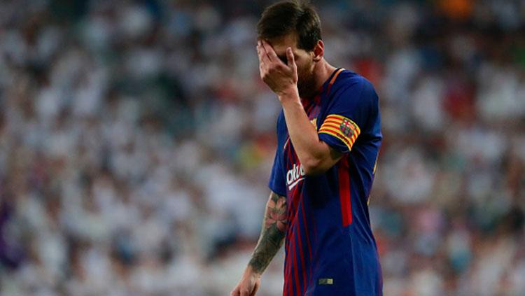 Lionel Messi menutup wajahnya usai Barcelona takluk dari Real Madrid. Copyright: INDOSPORT