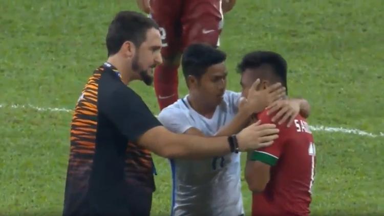 Saddil Ramdani coba ditenangi oleh staf pelatih dan pemain Malaysia. Copyright: internet