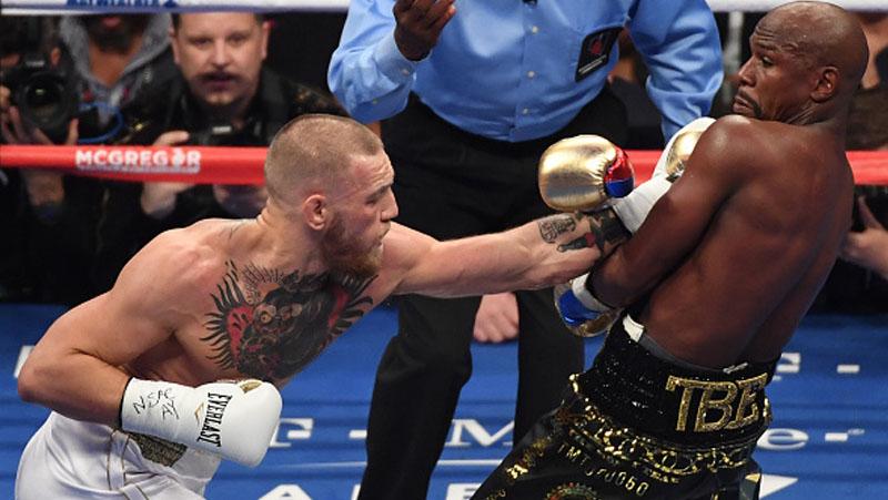 Floyd Mayweather menghindari pukulan cepat tangan kiri Conor McGregor.