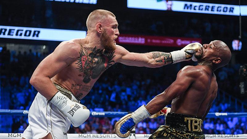 Wajah Floyd Mayweather terkena pukulan telak dari Conor McGregor.