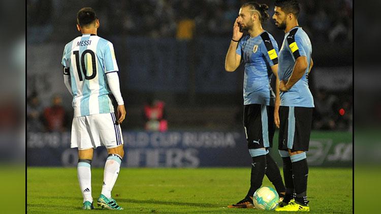 Lionel Messi (kiri/Argentina) dan dua pemain Timnas Uruguay, Gaston Silva (tengah), serta Luis Suarez. Copyright: INDOSPORT