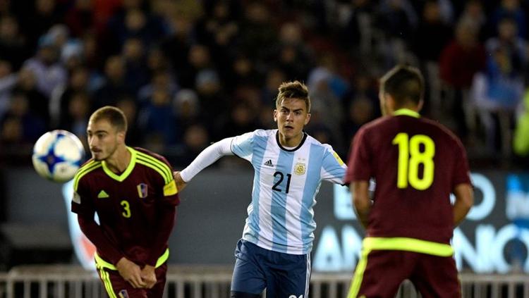 Paulo Dybala (Argentina) di tengah-tengah kedua pemain Venezuela. Copyright: INDOSPORT