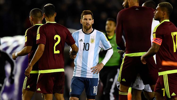 Lionel Messi berjabat tangah dengan salah satu pemain Venezuela. Copyright: INDOSPORT