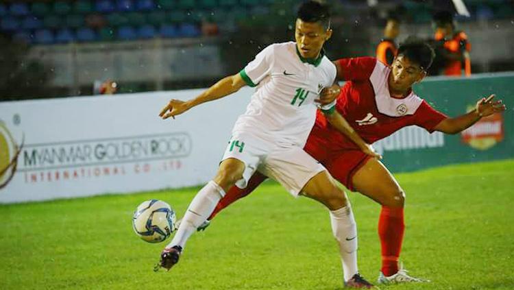 Feby Eka Putra mengontrol bola dari pemain Fiipina.