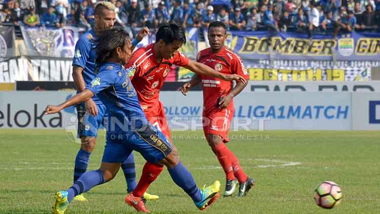 Duel lini tengah pemain Semen Padang dan Persib Bandung. Copyright: Indosport/Taufik Hidayat