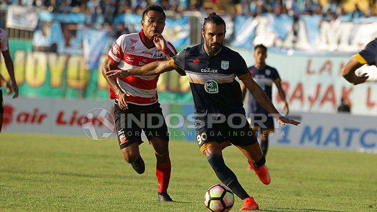 Jose Coelho (kanan) merebut bola dari pemain Madura United. Copyright: Ian Setiawan/INDOSPORT