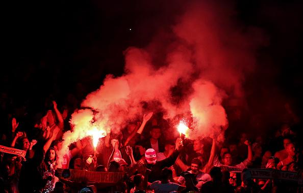 Suporter FC Koln menyalakan flare di dalam Emirates Stadium. Copyright: INDOSPORT