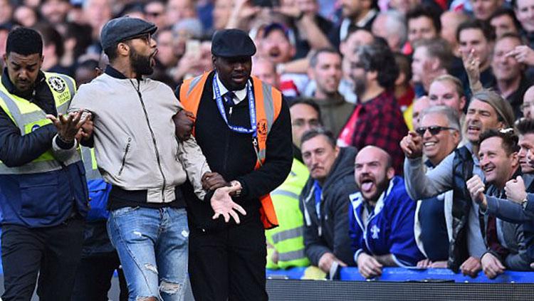 Salah satu fans Arsenal diamankan pihak keamanan Stadion Stamford Bridge. Copyright: INDOSPORT