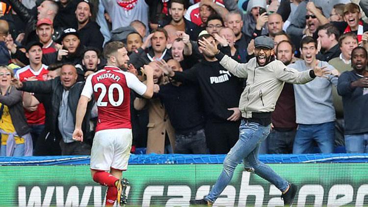 Salah satu fans Arsenal berlari ke arah Mustafi untuk merayakan golnya. Copyright: Lee Mills/Rex/Shutterstock