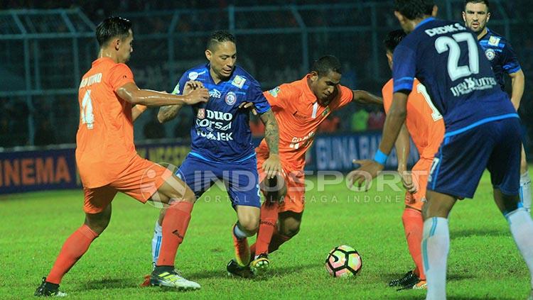 Mantan pemain Arema FC, Juan Pablo Pino dijaga ketat oleh Ryuji Utomo dan Pandi Lestaluhu.