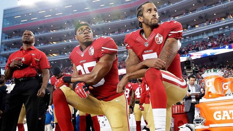 Colin Kaepernick (kanan) berlutut saat lagu kebangsaan Amerika dinyanyikan. Copyright: rollingstone.com