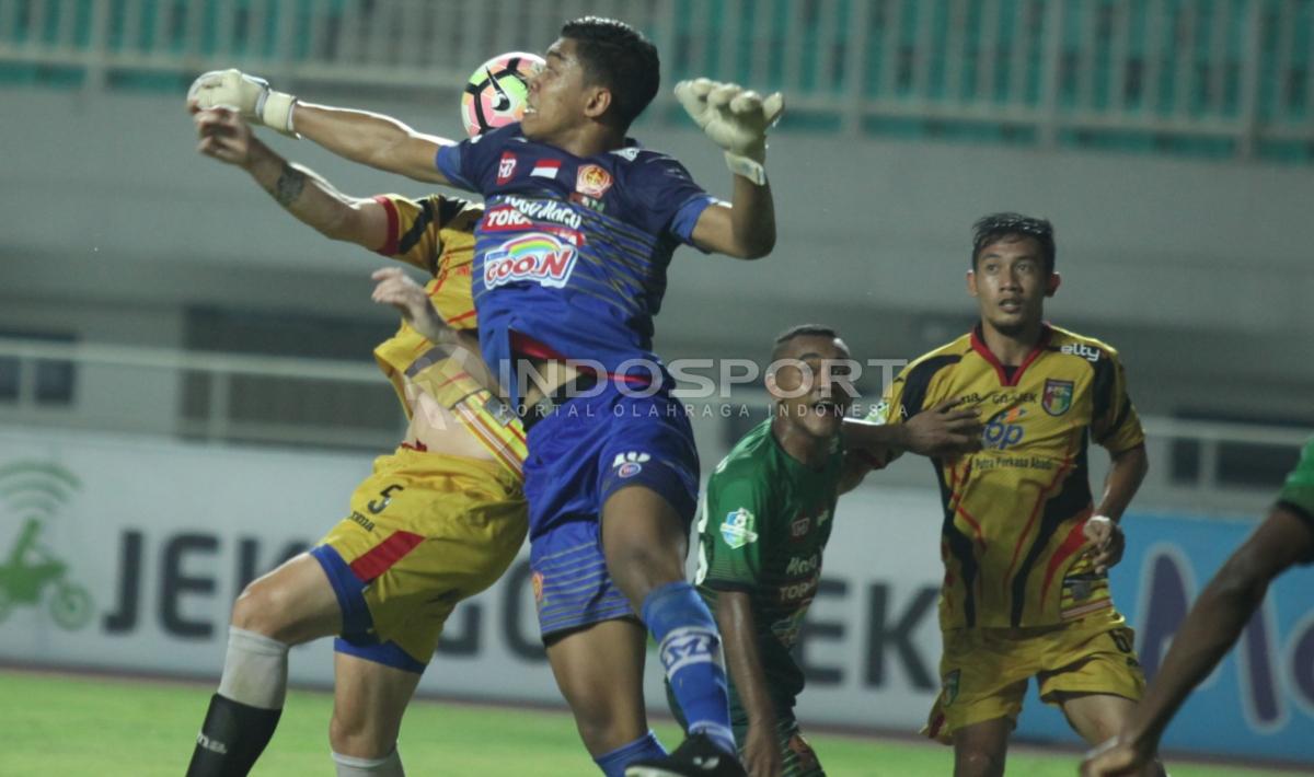 Duel antara kiper PS TNI, Teguh Amiruddin dengan bek Mitra Kukar, Jorge Gotor Blas (kiri).