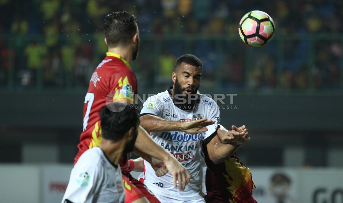Duel udara striker Bali United, Sylvano Domunique Comvalius (tengah) dengah gelandang BFC, Paulo Sergio. Copyright: INDOSPORT/Herry Ibrahim