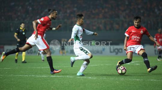 Pemain PS TNI, Manahati Lestusen (tengah) mencoba melewati Pemain Persija Jakarta. Herry Ibrahim/INDOSPORT