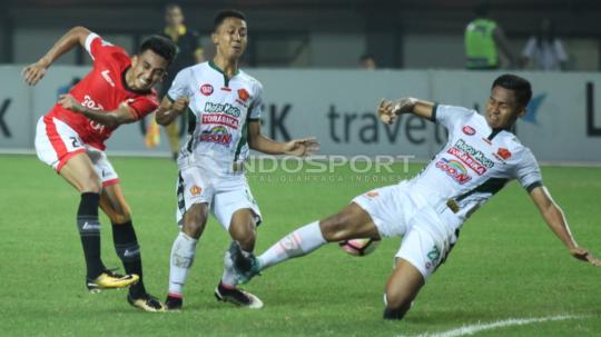 Tendangan pemain Persija Jakarta, Fitra Ridwan dihadang bek PS TNI, Franklin Anzite Touadere. Herry Ibrahim/INDOSPORT