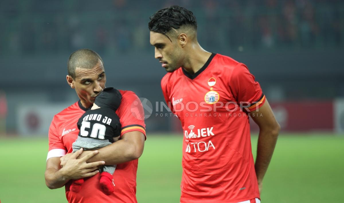 Striker Persija Bruno Lopes (kiri) membawa anaknya ke lapangan. Herry Ibrahim/INDOSPORT