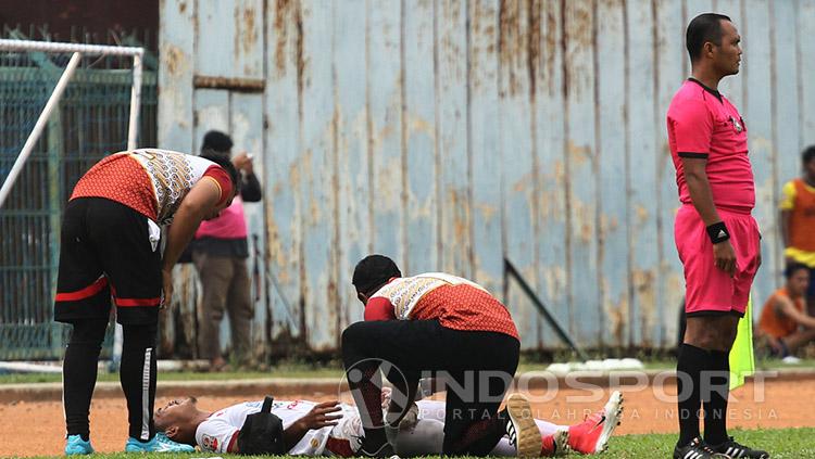 Seorang pemain Persis Solo harus tergeletak di pinggir lapangan. Copyright: INDOSPORT/Ghozi El Fitra