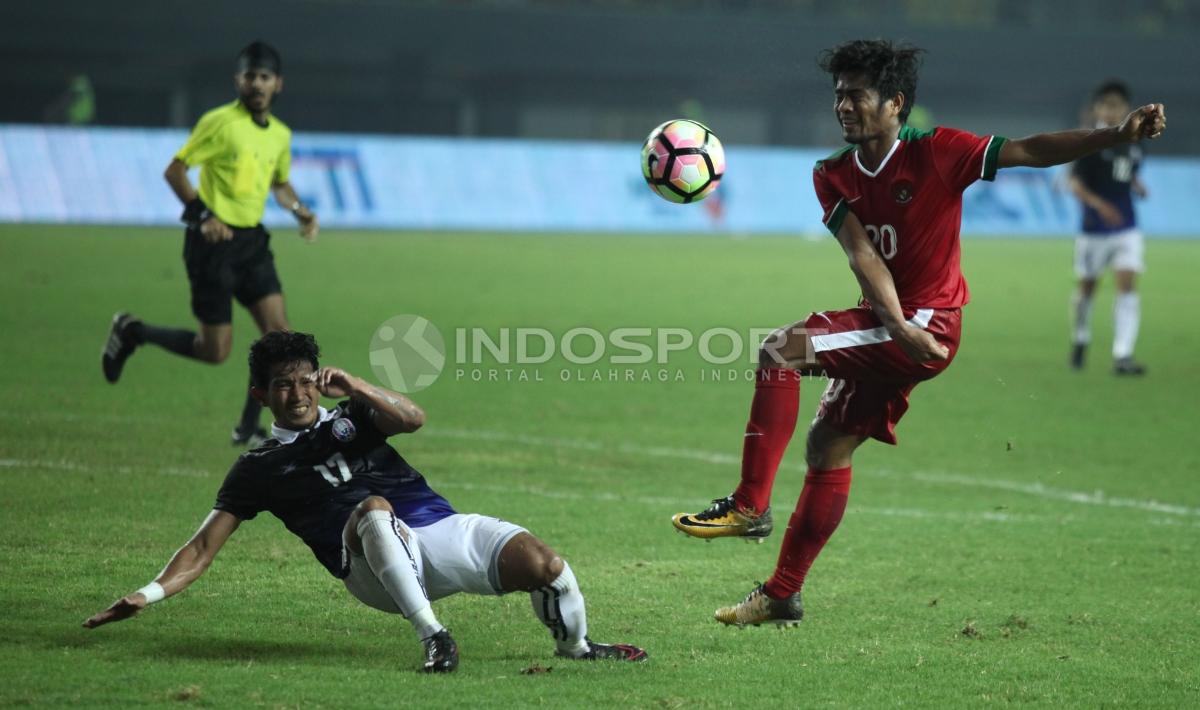 Ilham Udin Armayn saat berduel dengan pemain Kamboja.  INDOSPORT/Herry Ibrahim