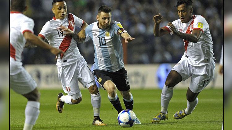 Lionel Messi (tengah) saat mendapat kepungan dari para pemain Timnas Peru. Copyright: INDOSPORT