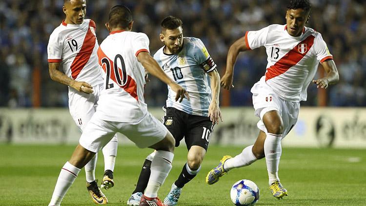 Lionel Messi mendapat pengawalan tiga pemain Peru. Copyright: GI