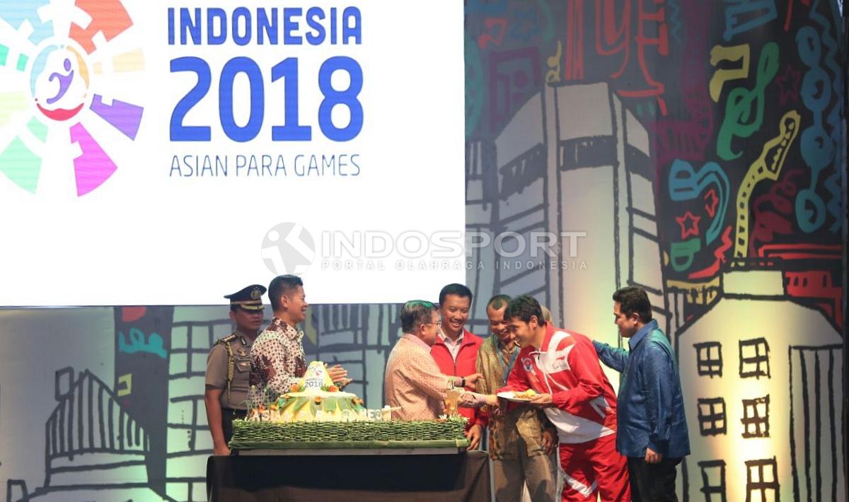 Wakil Presiden RI, Jusuf Kalla (tengah) memberi potongan tumpeng kepada perwakilan atlet pada acara peresmian hitung mundur Asian Para Games 2018. (INDOSPORT/Herry Ibrahim)