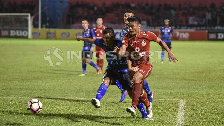 Duel antara pemain Semen Padang dan Madura United. Copyright: INDOSPORT/Taufik Hidayat