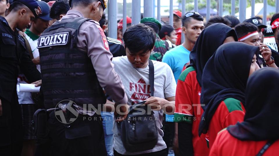 Petugas kepolisian melakukan pemeriksaan terhadap pendukung Timnas yang akan memasuki stadion. Copyright: Hery Ibrahim/Indosport