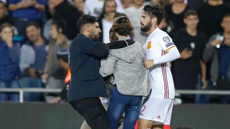 Isco dan keamanan tengah mengawal seorang penggemar ke  luar lapangan di Yerusalem. Copyright: thesun.co.uk