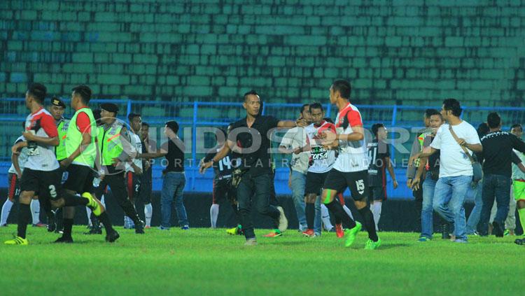 Puluhan%20anggota%20polisi%20termasuk%20intel%2C%20berusaha%20mengamankan%20tawuran%20massal%20kedua%20tim%20yang%20memuncak%20di%20menit%2086%2C%20sekaligus%20menghentikan%20laga.