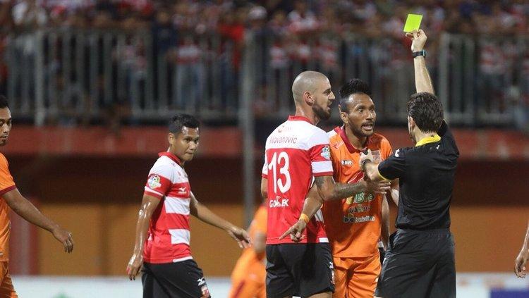Wasit mengeluarkan kartu saat pimpin Madura United vs Borneo FC. Copyright: Borneofc.id